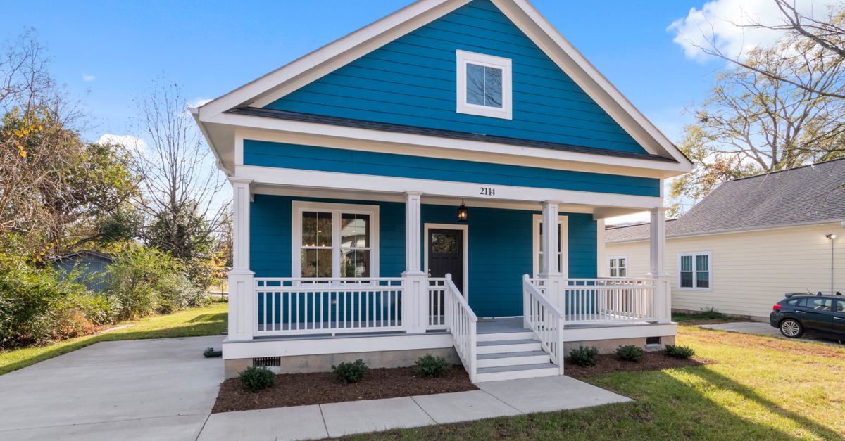 Exterior view of a blue suburban house with a welcoming front porch representing property division in divorce cases